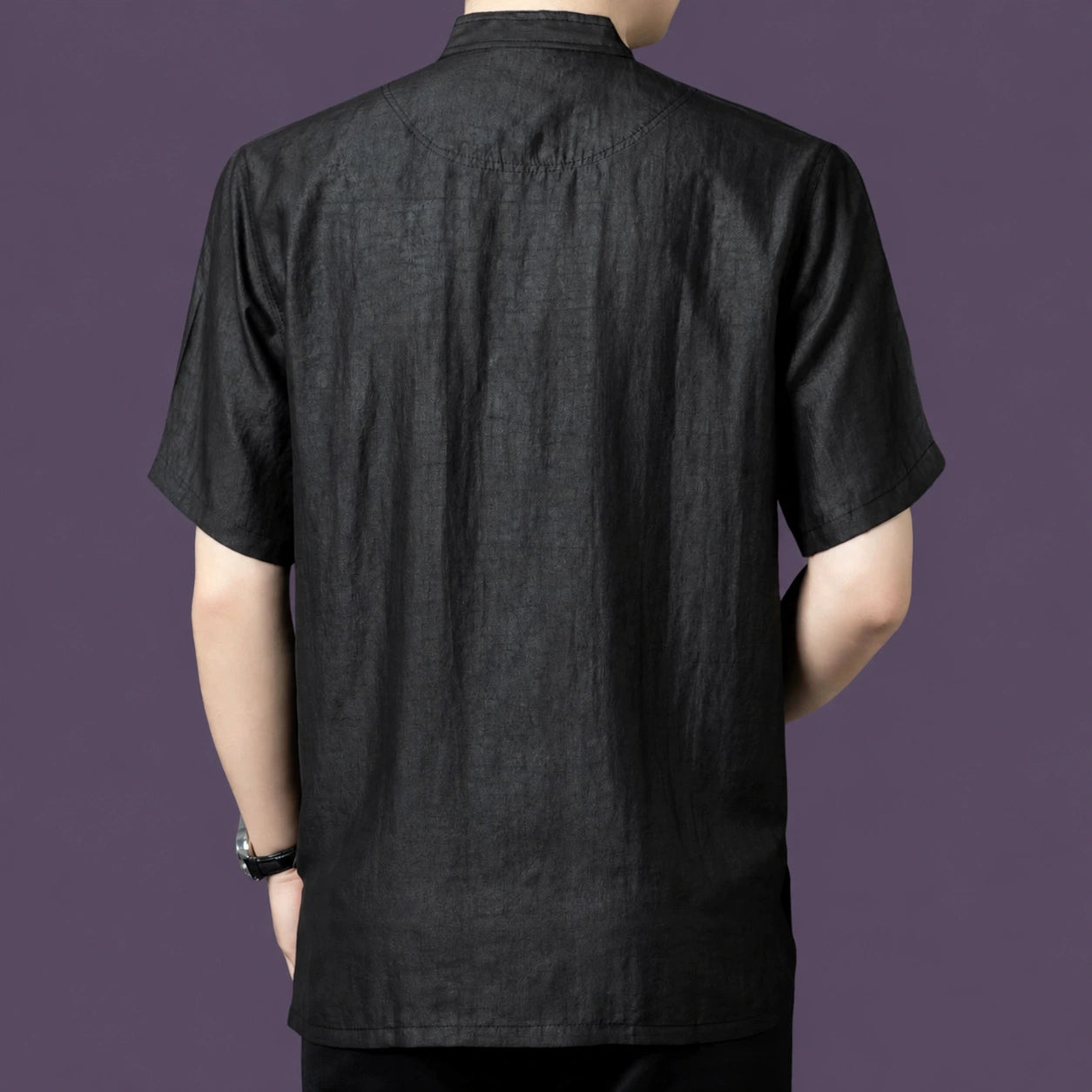 Back view of the black silk henley shirt, showcasing the relaxed drape and simple, clean back construction.