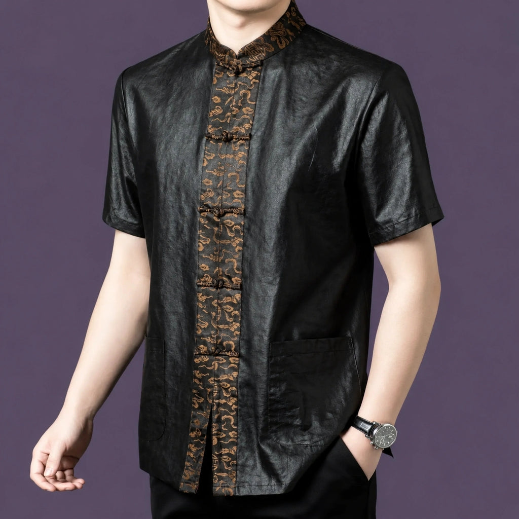 Men's black silk short-sleeve shirt with patch pockets and an ornate bronze jacquard placket, styled with a watch and black trousers.