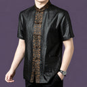 Men's black silk short-sleeve shirt with patch pockets and an ornate bronze jacquard placket, styled with a watch and black trousers.