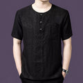 Men's black 100% mulberry silk short-sleeve henley shirt with a round neck, 3-button placket, and single chest pocket, styled with black trousers.