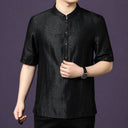 Close-up of the black silk shirt, showing the fine stitching details along the front placket and button accents.