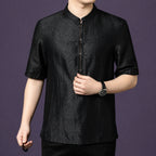 Close-up of the black silk shirt, showing the fine stitching details along the front placket and button accents.
