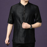 Close-up of the black silk shirt, showing the fine stitching details along the front placket and button accents.