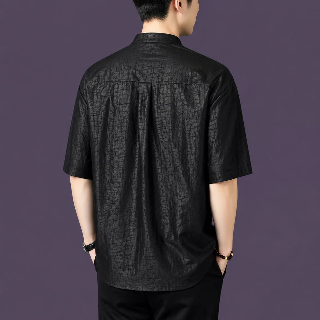Back view of a men's black 100% mulberry silk short-sleeve shirt with a mandarin collar, featuring a unique cracked matte texture.