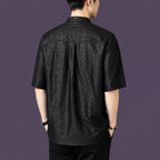 Back view of a men's black 100% mulberry silk short-sleeve shirt with a mandarin collar, featuring a unique cracked matte texture.
