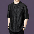 Front view of a men's black short-sleeve silk shirt with a stand collar, two patch pockets, and a relaxed straight cut.