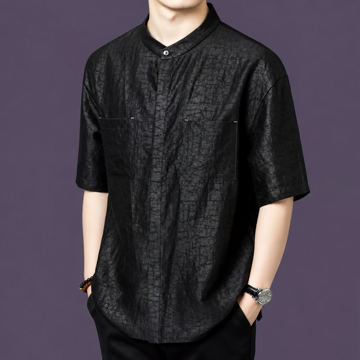 Front view of a men's black short-sleeve silk shirt with a stand collar, two patch pockets, and a relaxed straight cut.