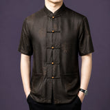 Men's dark brown 100% mulberry silk short-sleeve shirt featuring a traditional stand collar, geometric jacquard base pattern, and round wooden frog buttons.