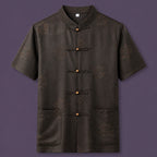 Flat lay of the men's short-sleeve silk shirt, showing the detailed geometric pattern, wooden button details, and patch pockets.