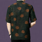 Back view of the dark green silk shirt, highlighting the large, blurred rust-colored dots that scatter across the matte fabric.
