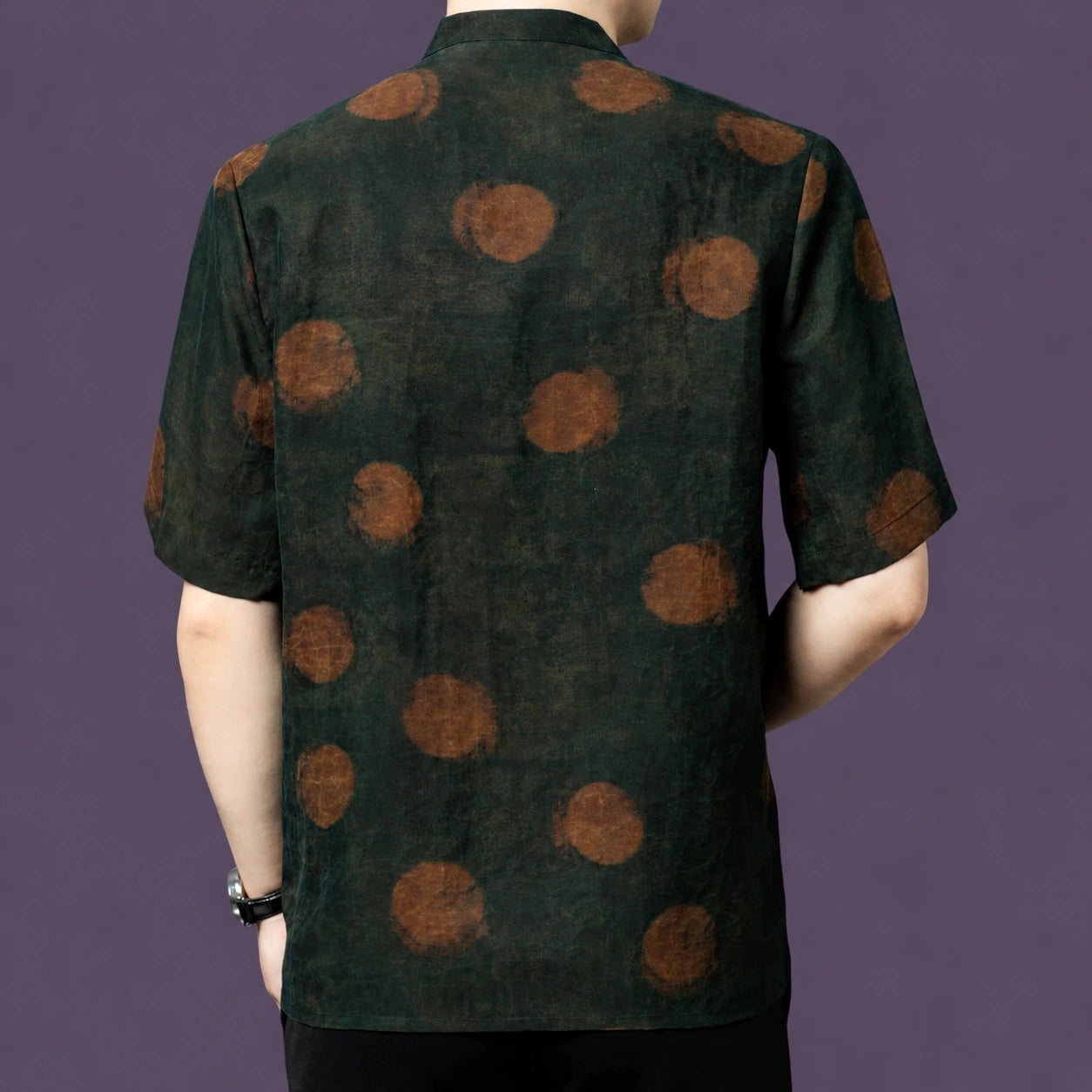 Back view of the dark green silk shirt, highlighting the large, blurred rust-colored dots that scatter across the matte fabric.