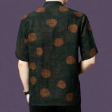 Back view of the dark green silk shirt, highlighting the large, blurred rust-colored dots that scatter across the matte fabric.