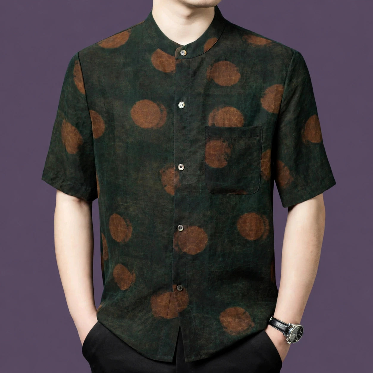 Men's dark green 100% mulberry silk short-sleeve shirt with a stand collar and rust-brown watercolor polka dot pattern, styled with black trousers.