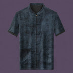 Flat lay of the men's grey silk short-sleeve top featuring a mandarin collar, six frog buttons, two patch pockets, and contrast binding on the cuffs.