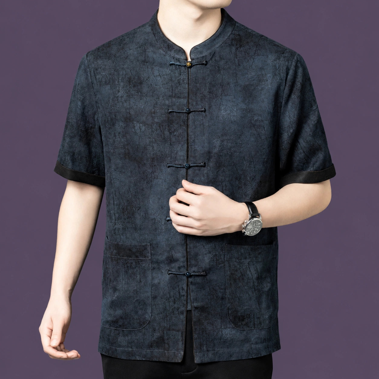 Close-up angle of the men's silk tang-style shirt showing the dark contrast trim on the sleeves and the relaxed straight fit.