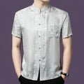 Men's silver-grey 100% mulberry silk short-sleeve shirt with a stand collar, button placket, and single chest pocket, featuring a subtle floral jacquard pattern.