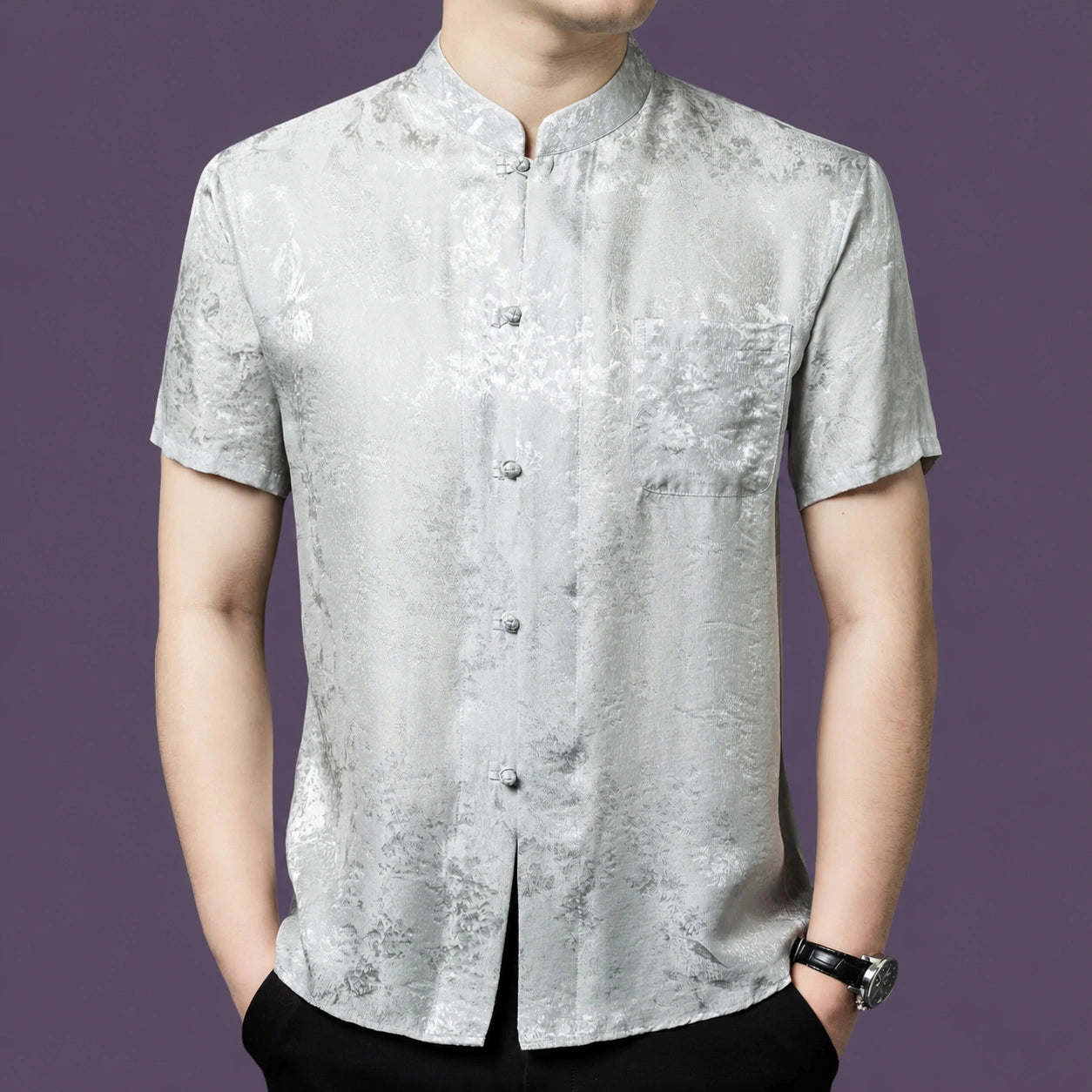 Men's silver-grey 100% mulberry silk short-sleeve shirt with a stand collar, button placket, and single chest pocket, featuring a subtle floral jacquard pattern.