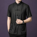 Close-up of a men's black mulberry silk Mandarin collar shirt with embroidered pockets and traditional frog button closure.