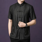 Close-up of a men's black mulberry silk Mandarin collar shirt with embroidered pockets and traditional frog button closure.
