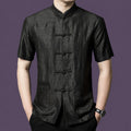 Front view of a man wearing a black 100% mulberry silk mandarin collar shirt with frog buttons.