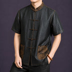 Angled view of a men's black mulberry silk Tang shirt featuring a Mandarin collar, frog closures and decorative contrast stitching.