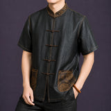 Angled view of a men's black mulberry silk Tang shirt featuring a Mandarin collar, frog closures and decorative contrast stitching.