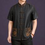 Men's black 100% mulberry silk Tang shirt with Mandarin collar, traditional frog buttons and contrast embroidered pockets, front view.
