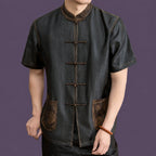 Model wearing a black 100% mulberry silk Chinese Tang shirt with short sleeves and traditional frog button fastening.
