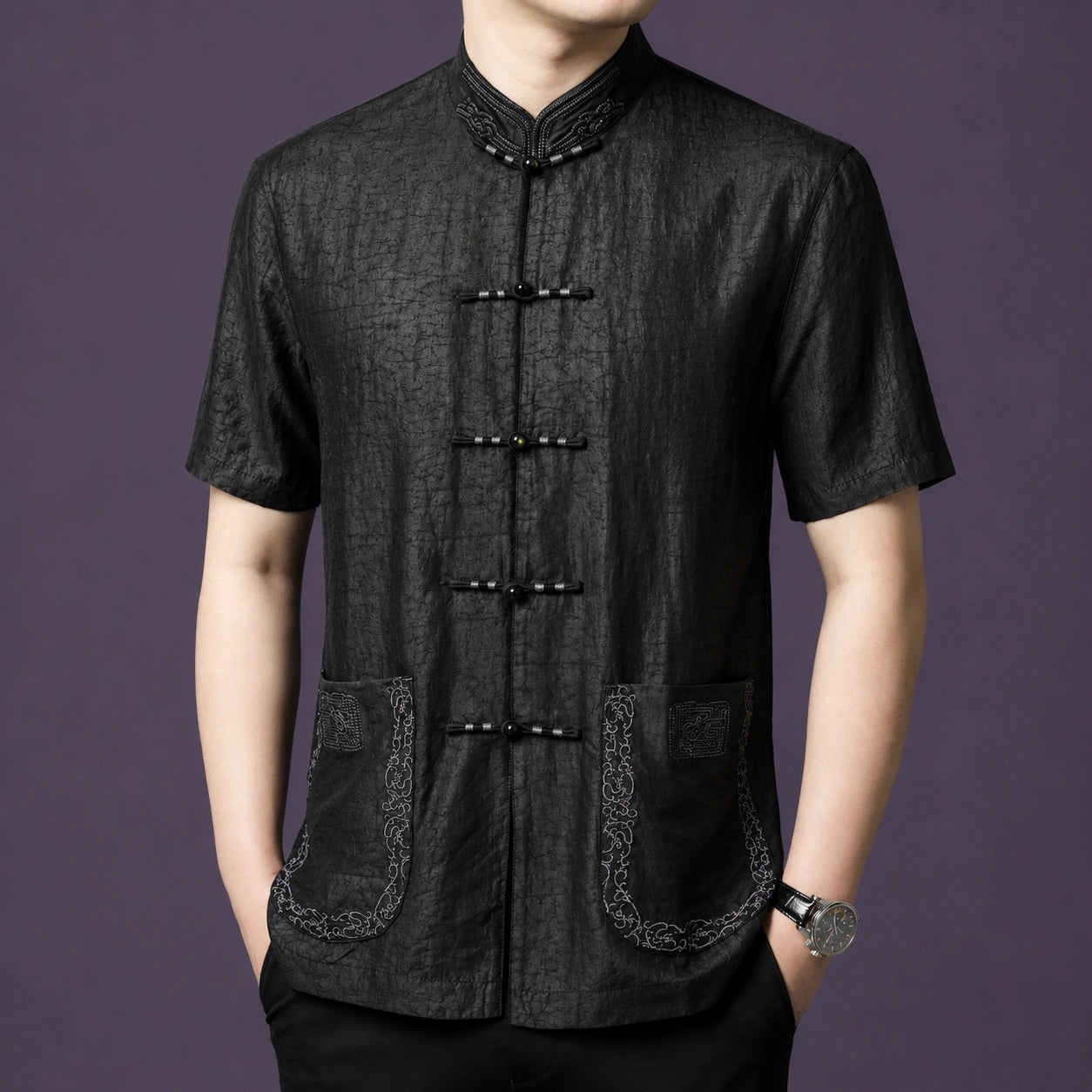 Model wearing a black embroidered mulberry silk Tang shirt with Mandarin collar and frog buttons.