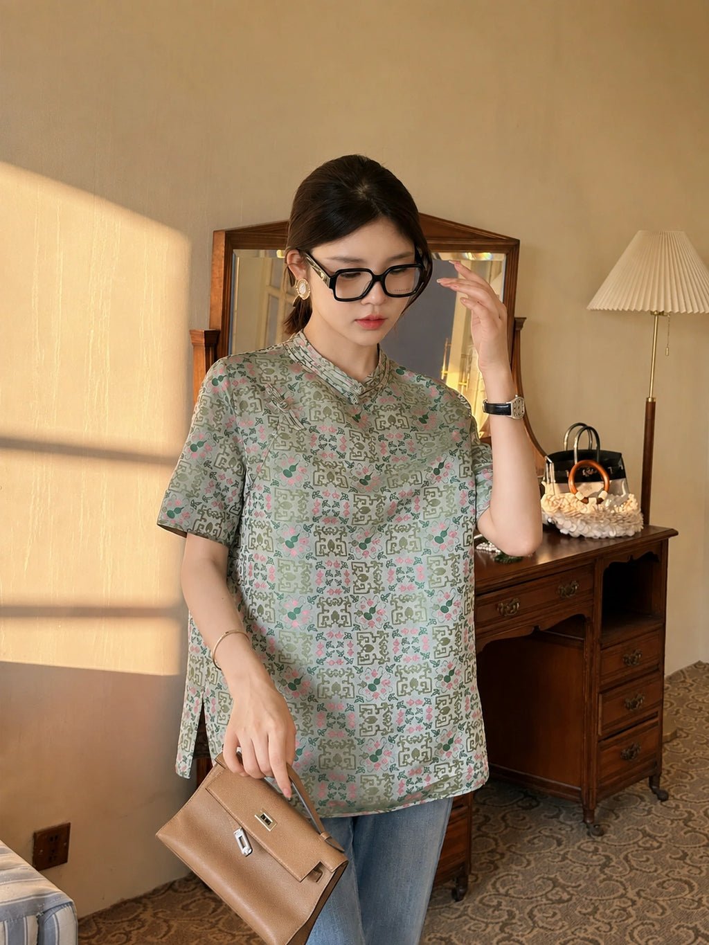 Model styling a mint green printed Chinese-inspired dress with jeans and accessories