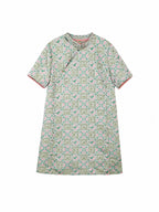 Flat lay of a mint green Chinese-inspired dress with a geometric floral print and round neckline