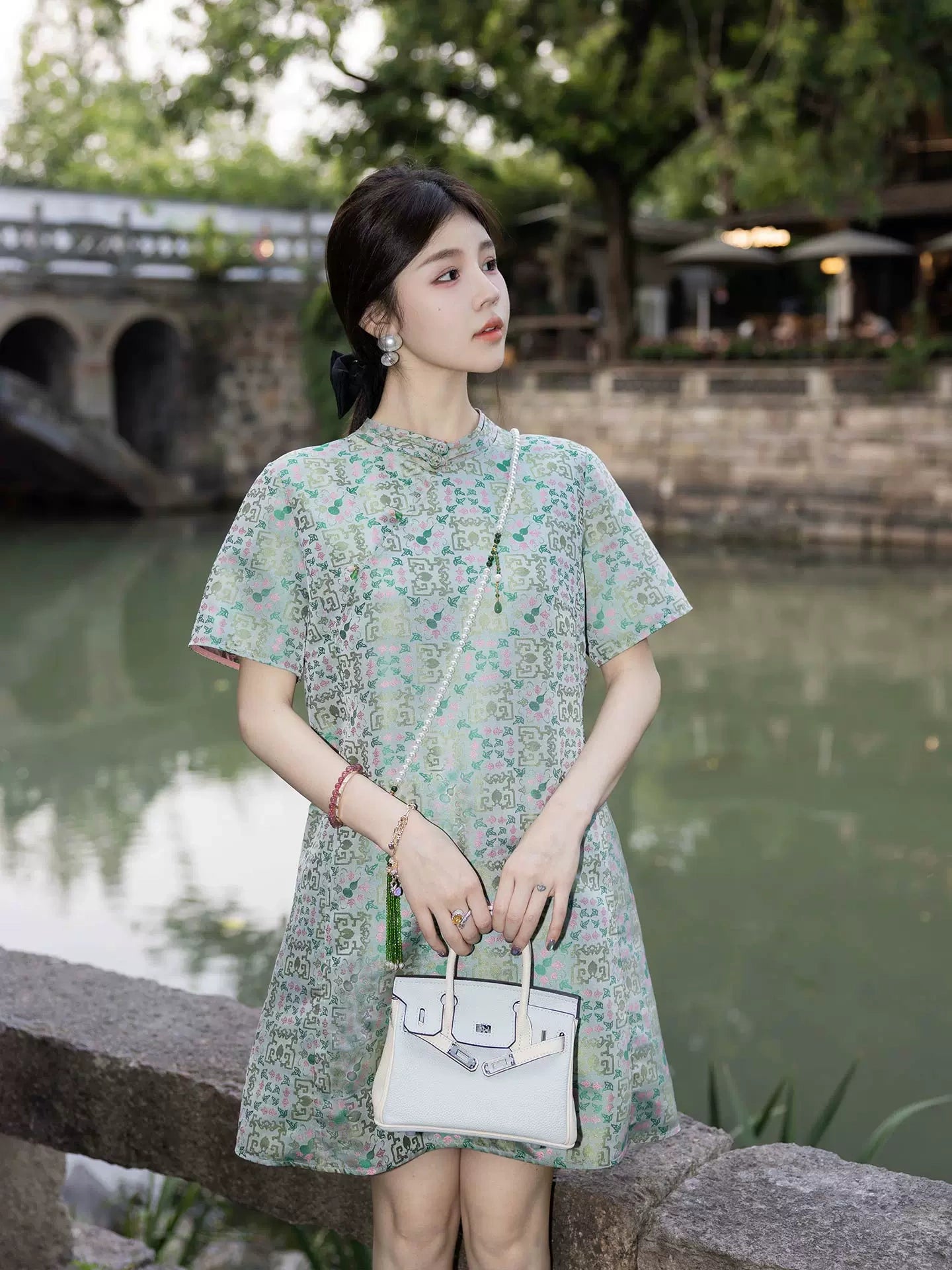 Model wearing a mint green silk-blend dress with a relaxed straight silhouette and patterned fabric