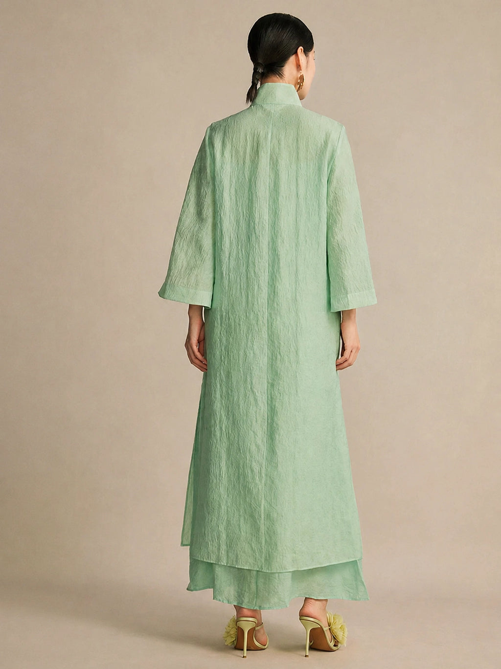 Back view of the mint green long dress, highlighting its relaxed, straight drape and the subtle layered hem detail at the bottom.
