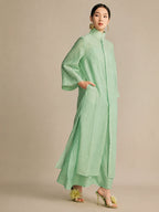 Side view of the mint green dress featuring an inseam side pocket and wide sleeves, demonstrating its lightweight, breathable fabric and comfortable fit.