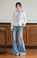Model styling the jacquard vest with a white inner top and wide-leg jeans.