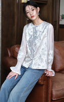 Seated styling view of the mist silver jacquard vest paired with jeans.