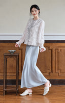 Model wearing the mist silver jacquard vest over a white long-sleeve top with a pale blue skirt.