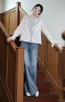 Model wearing the mist silver vest with a white inner top and jeans on a wooden staircase.