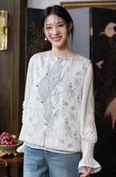Closer view of the vest’s silver-toned floral jacquard, blue buttons and asymmetric front panel.