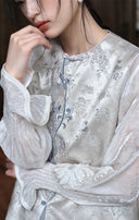 Close-up of the vest’s round neckline, decorative knot and blue embroidery on the front panel.