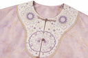 Close-up of the floral embroidery, rounded neckline and decorative front closures