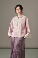 Model wearing the pale purple jacket with a matching pleated skirt