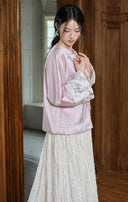 Model wearing the misty lavender embroidered jacket with an ivory skirt, shown from the side.
