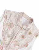 Close-up of the stand collar, decorative closure and detailed embroidery on the porcelain white vest.