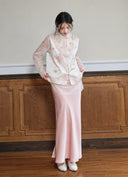 Model wearing the Moon Porcelain White embroidered vest over a sheer long-sleeve top with a pink skirt.