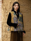 Model wearing the patterned hemp side of the Moxu vest, showing gold, purple and green motifs and a drawstring hem.