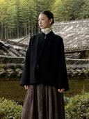 Model wearing the Jinyu Black wool coat with a brown skirt outdoors.