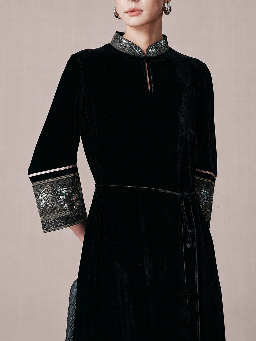 Close-up of the mandarin collar and brocade trim on a black mulberry silk dress