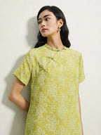 Close-up of handcrafted frog buttons on a light green mulberry silk floral dress.