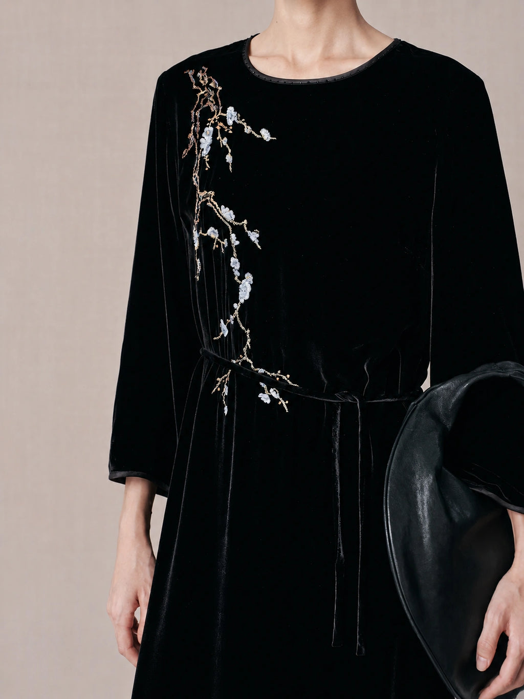Close-up of floral branch embroidery on black mulberry silk dress.